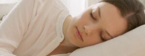 Jeune femme endormie paisiblement, illustrant le lien entre stress et sommeil